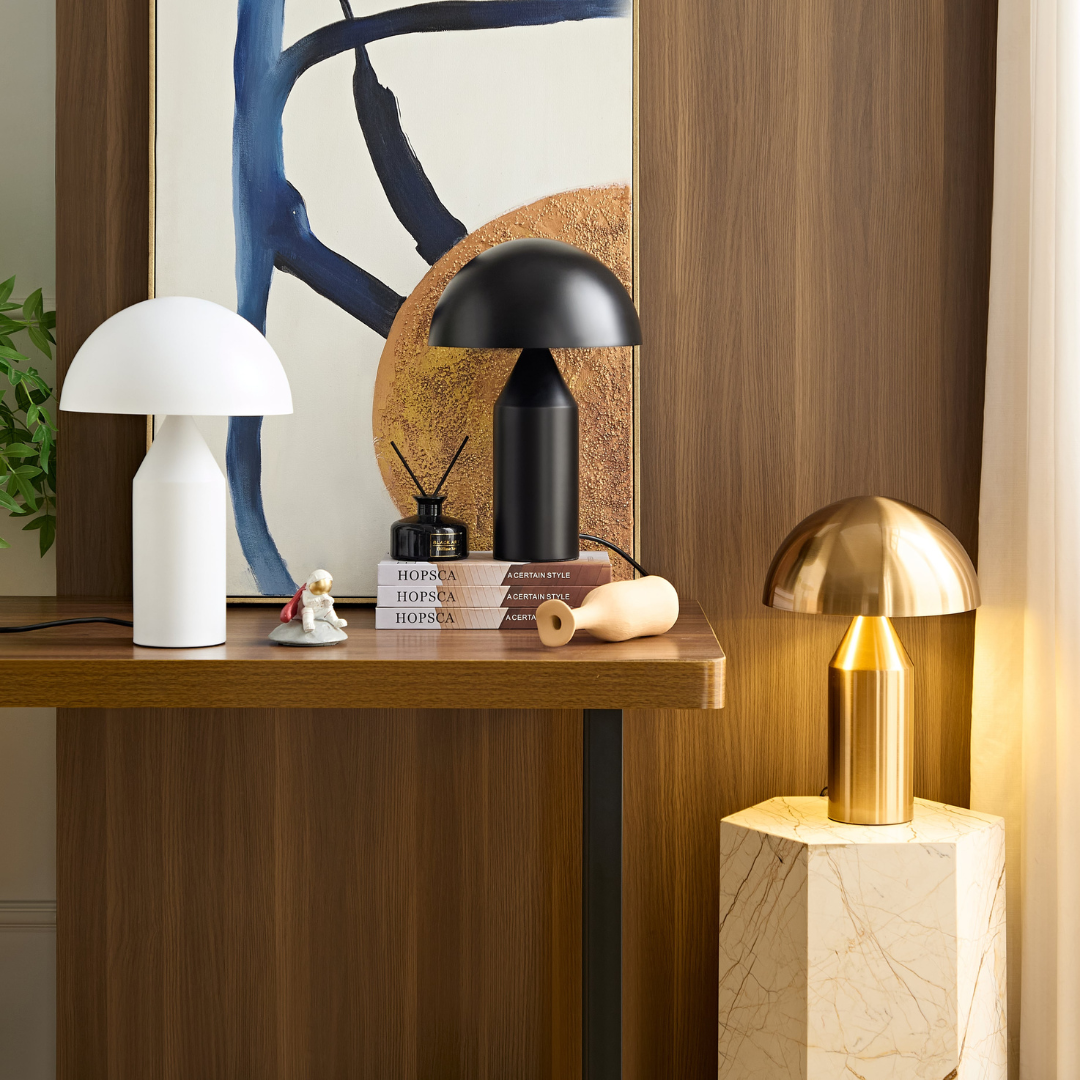 A white, black and gold brass table lamp on a table