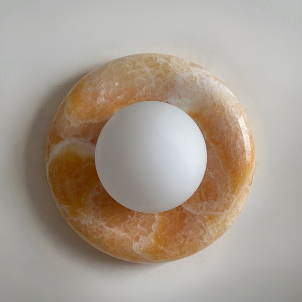 Round stone object with a white sphere in the center on a light gray background