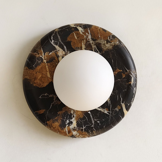 Round marble coaster with a white sphere on a light background
